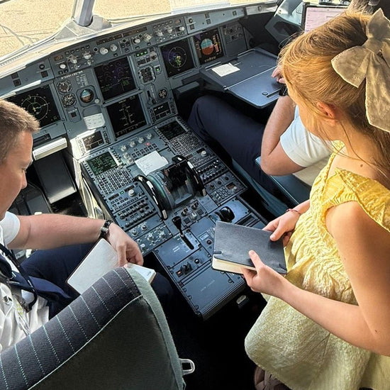 Flight log book being signed by a pilot inside an airplane cockpit.