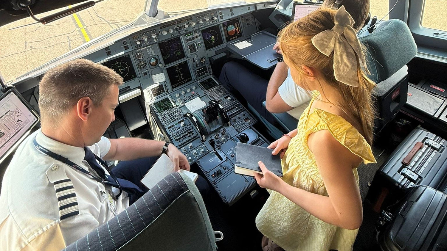 Flight log book being signed by a pilot inside an airplane cockpit.